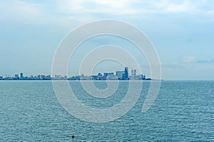 Black sea seascape with red buoy and Batumi city silhouette in Georgia