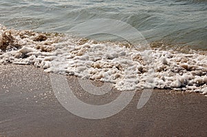 Black Sea. Water with waves. Mainly cloudy weather and sun rays. Blue and grey clouds. Before rain. Sand coast