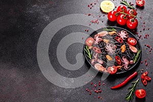 Black seafood pasta with shrimp, octopus and mussels on black background. Mediterranean gourmet food
