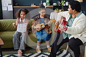 Black Senior Woman with Two Children Playing Music