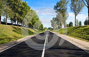 Black serpentine of asphalt road in sunny day.