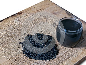 Black sesame drinking in cup with sesame seed on chopping block