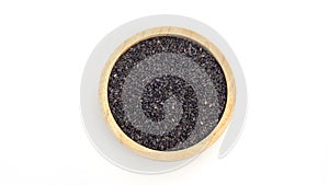 Black sesame seeds in a bowl on a white background