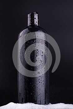 Black shampoo bottle on black background