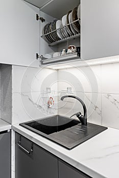 Black shell and matte black crane located on white surfaces of porcelain plates that imitate the appearance of natural