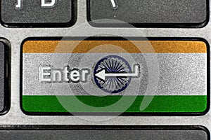Black shiny keyboard closeup, focus on the Enter key India flag
