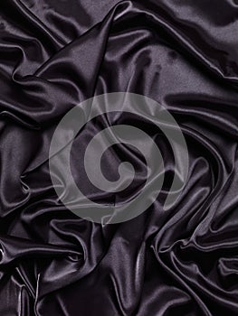 Black shiny silky fabric abstract background