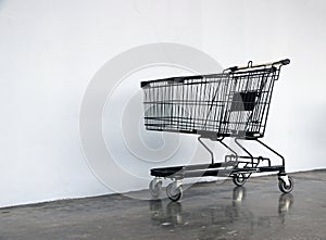 Black shopping Cart on the floor and white background.