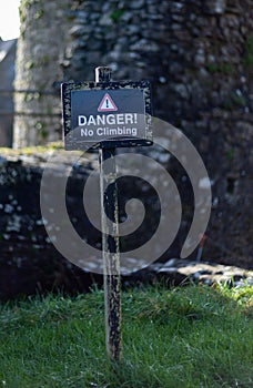 Black sign in front of a stone wall