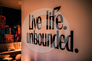 A black sign on a wall that says live life unbounded, AI