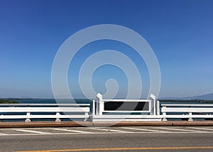 Black signboard or billboard with copy space to add your own text on white cement bridge across the sea.