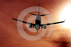 Black silhouette of airplane against the sun