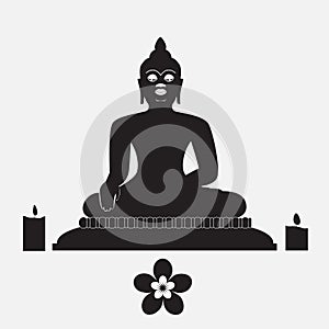 Black silhouette of Buddha with candle and flower