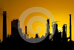 Black silhouette of crude oil refinery station during sunset