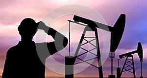 Black silhouette of oil worker and pump jack