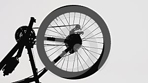 Black silhouette of a part of a modern sports bike on a white isolated background. Close up of a round bicycle wheel