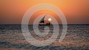 Black Silhouette Of Sailing Ship Floating On Sea At Sunset With Big Red Sun