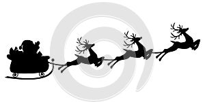 Black silhouette of Santa flying in a sleigh with reindeer.