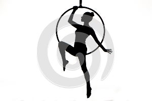 Black silhouette of a young woman posing on an air ring on an isolated white studio background. Female aerial acrobat