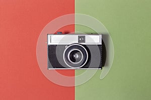 Black and silver analog camera. vintage. zenith view on red and green background. resurgence of film photography