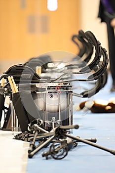 Black and silver tenor drums with harnesses on gym floor