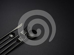 Black silverware over a black background