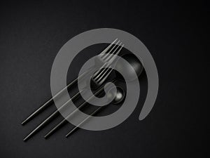 Black silverware over a black background