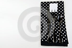 Black silverware on polka dot napkin