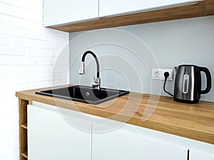Black sink with flexible faucet in Scandi kitchen interior