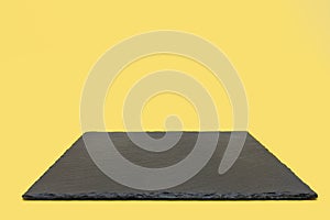 Black slate board on a yellow background