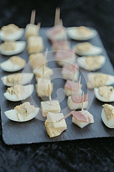 the black slate plate holds mini appetizers on a table