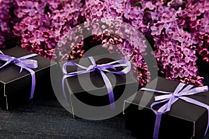 Black small gift boxes wrapped purple ribbon with natural lilac