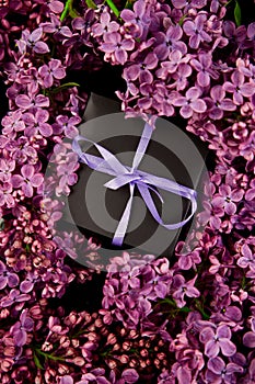 Black small gift boxes wrapped purple ribbon with natural lilac