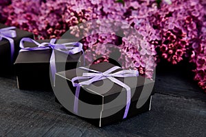 Black small gift boxes wrapped purple ribbon with natural lilac