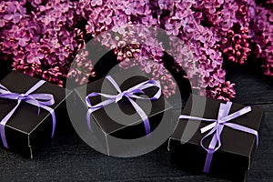 Black small gift boxes wrapped purple ribbon with natural lilac