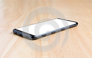 Black smart phone with white screen on the wooden table