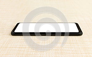 Black smart phone with white screen on the wooden table