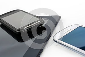 Black Smartphone On Black Tablet With White Mobile Besides