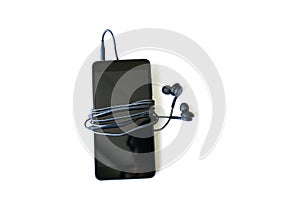 Black smartphone with earphones is lying on white background. Modern technology connection. Digital cell