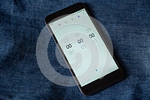 Black smartphone with the Time Countdown App open. Zeros on the screen of the device. The starting point of the countdown. Against