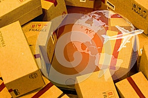 Black smartphone with World map on pile of cardboard boxes. concept of International freight or shipping service for online