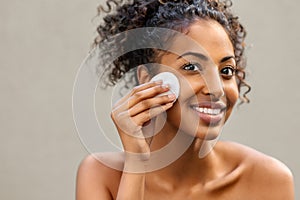 Black smiling woman remove make up