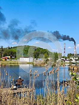Black smoke rises from the plant\'s pipes against a blue sky
