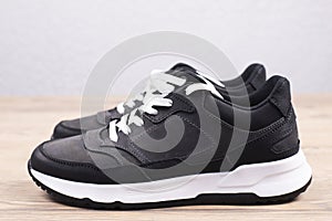Black sneakers on a wooden background. Sports shoes.