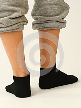black sock with copy space on human foot closeup photo on white background