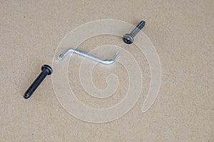 Black socket button and silver hexagonal wrench on brown background