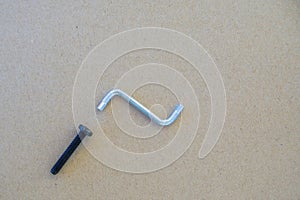 Black socket button and silver hexagonal wrench on brown background