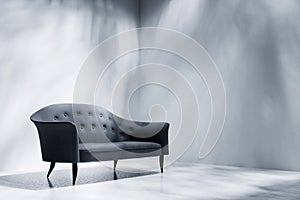 Black sofa in empty room with white wall
