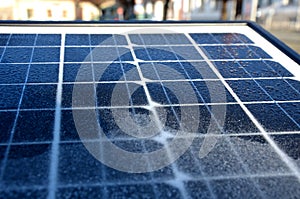 Black solar panel frozen by hoarfrost on the street. used to charge the device parking meter, information interactive screen, traf