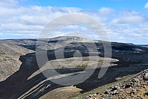 Black and solidified lava flow on the mountains of a volcano in Iceland North of Europe